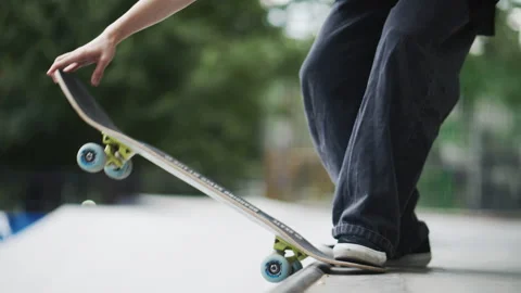 Close up of skateboarder performing grind trick on rail at outdoor skatepark Stock Footage 345416294