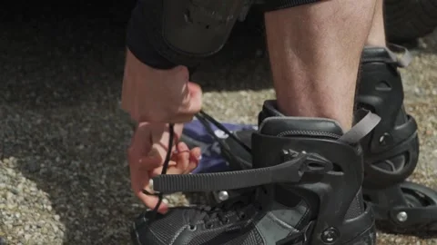 Close-Up of Skater Tying Laces on Inline Skates Before Action Sports Session Stock Footage 304963875