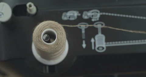 Close-up skein thread of gray thread on a working professional sewing machine Stock Footage 121536316