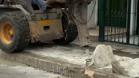 Close-up of a skid steer loader with hydraulic hammer breaking and demolishing 動画素材 160376390