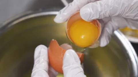 Close-up of Skilful Hand Separating Egg Yolk from White for Dessert Preparation Stock Footage 337751721