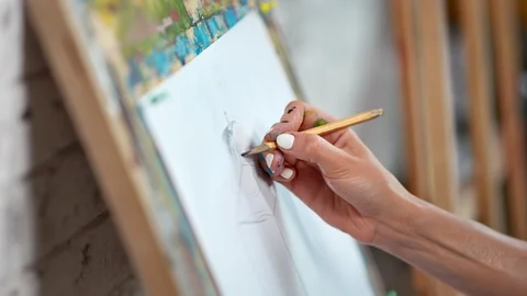 Close-up skilled female painter hand drawing sketch on white paper canvas using Stock Footage 109049077