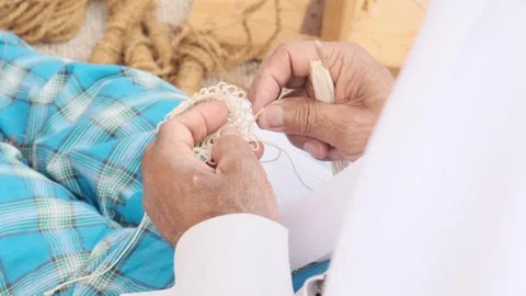 Close up of skilled hands repairing net in traditional Arab fishing culture Stock Footage 343665945