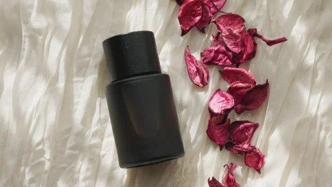 Close-up of a Sleek Black Perfume Bottle and Dried Roses Vidéo 330589566