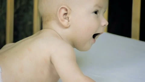Close-up of a sleepy five-month newborn lying on his stomach in a diaper on ... Stock Footage 102152801