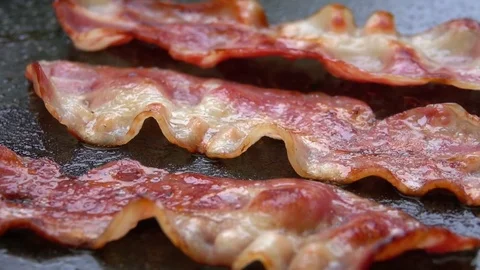 Close-up of a slice of bacon fried on grill Stock Footage