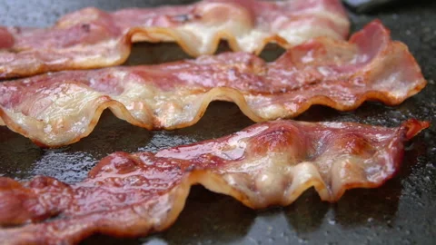 Close-up of a slice of bacon fried on grill Stock Footage 88560824