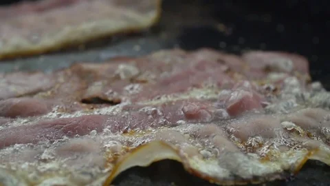 Close-up of a slice of bacon fried on a hot grill Video stock 104972782