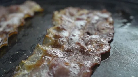 Close-up of a slice of bacon fried on a hot grill 動画素材 104972829