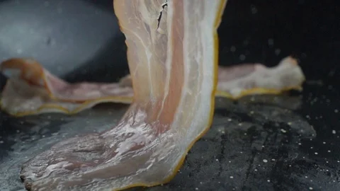 Close-up of a slice of bacon fried on a hot grill Video stock 104972868