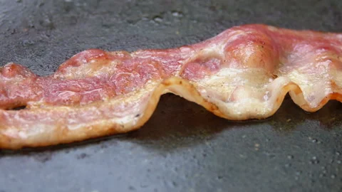 Close-up of a slice of bacon roasted on a stone grill Stock Footage 88560415
