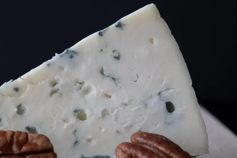 Close-up of a slice of blue cheese with visible mold veins and pecan nuts o.. Foto stock