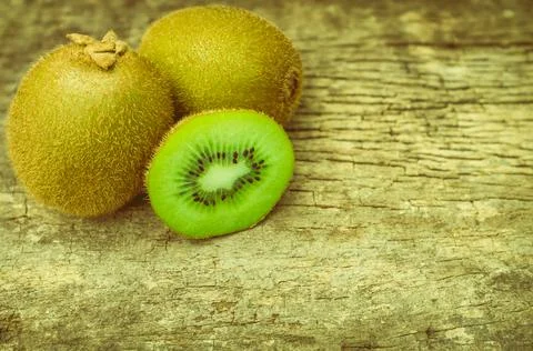 Close up slice of fresh kiwi fruit on old wood background. Stock Photos