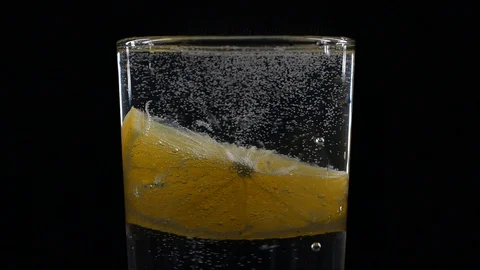 Close-up slice of lemon fruit in a glass of soda with bubbles Stock Footage 123510756