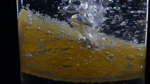 Close-up slice of lemon fruit in a glass of soda with bubbles Video stock 123510765