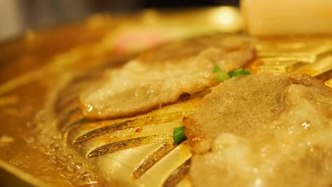 Close-up of a slice of pork fried on a hot grill. Stock Footage 94165274