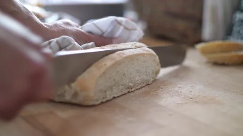 Close up of a slice of white bread being cut from a loaf on a wooden 스톡 동영상 142919510