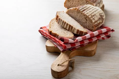 Close-up of sliced bread with checked pattern napkin on serving board with copy Stock Photos