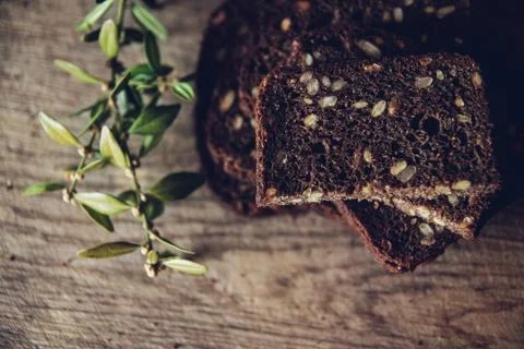 Close-up of the sliced brown bread at the cutting board on the wooden table w Foto stock