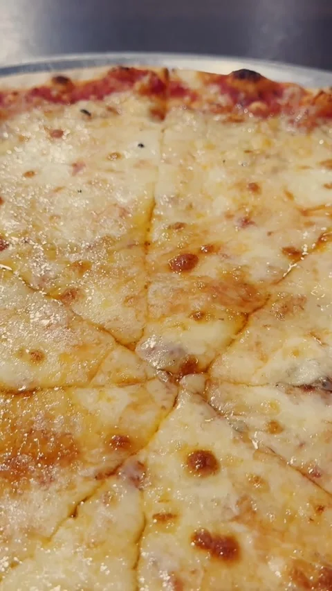 Close-up of sliced cheese pizza with melted mozzarella, tomato sauce and Stock Footage 337228946