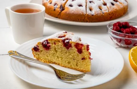 Close-up of a sliced cherry pie, a slice of pie on a plate, and lemon tea. Stock Photos