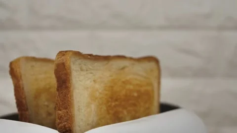 Close-up of sliced fried white bread flying out of an electric toaster on a Stock Footage 235400700
