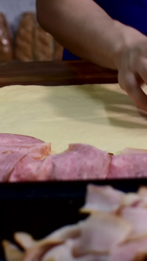Close up of sliced ham on fresh pastry dough for baking preparation Stock Footage 336697174