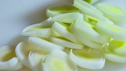Close-up. Sliced, leeks piled on a white kitchen board. Stock Footage 302735428