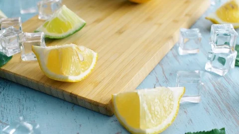 Close up of sliced lime and lemon on wood kitchen surface. Fresh citrus fruits w Stock Footage 114633514