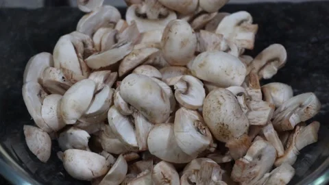 Close-up of sliced mushrooms on a plate on the table to prepare homemade pizza Stock Footage 164580096