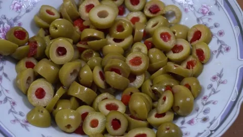 Close-up of sliced olives on a plate on the table to prepare homemade pizza in Stock Footage 164579885