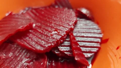 Close-up of sliced pickled beetroot with wavy texture in an orange bowl Stock Footage 335572480