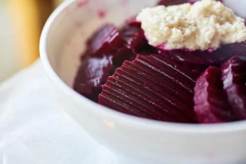 Close-up of sliced red beetroot salad served with fresh horseradish in whit.. Stock Photos