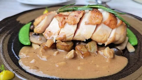 Close-up of sliced roasted chicken breast served with brown mushroom sauce Video stock 310847380