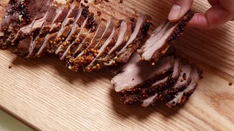 Close-up of Sliced Roasted Meat with Mustard Seeds on Wooden Board Stock Footage 333582766