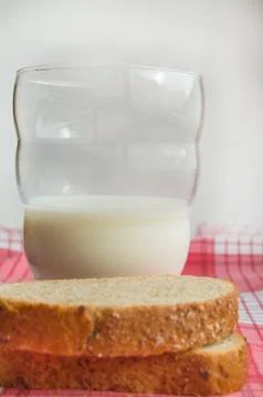 Close-up of Sliced rye bread and a glass of milk on a cloth red napkin, rusti Stock Photos