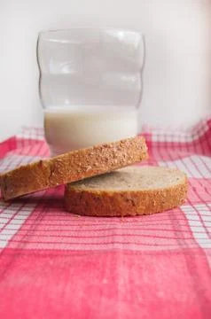 Close-up of Sliced rye bread and a glass of milk on a cloth red napkin, rusti Stock Photos