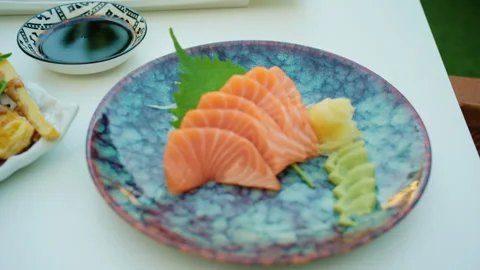 Close-up of sliced salmon sashimi with a shiso leaf, wasabi and pickled ginger Stock Footage 344793507