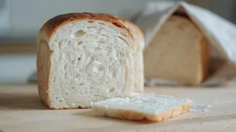 Close-up of a sliced white bread loaf showing soft crumb texture on a wooden Stock Photos