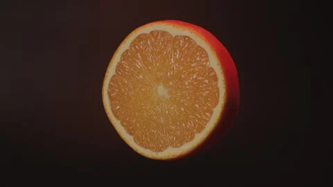 Close up slices of orange on a black background with rotating movement. Stock Footage 303069694