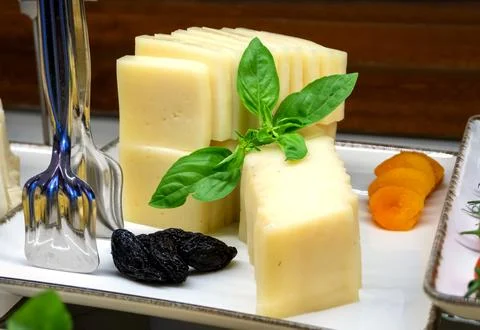Close-up of slices of processed cheese arranged on a tray with dried fruits.. Stock Photos