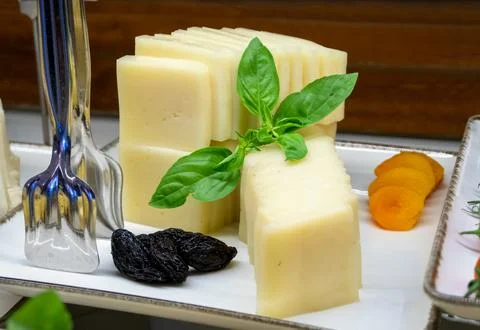 Close-up of slices of processed cheese arranged on a tray with dried fruits.. Stock Photos