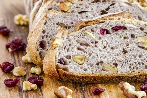Close up of slices of walnut cranberry bread sitting on wooden cutting board Stock Photos