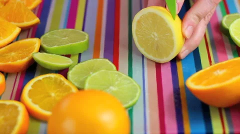 Close up slicing lemon and orange in colorful kitchen scene Stock Footage 42181242