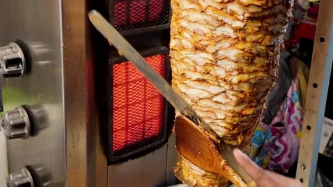 Close-Up of Slicing Marinated Chicken Shawarma Meat from Vertical Rotisserie 스톡 동영상 337649189