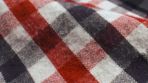 Close up slide over a red, white, and blue checked cotton shirt. Video stock 134985776