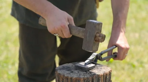 Close up slide shot of blacksmith who shapes hot steal with a hammer Stock-Footage 66273904