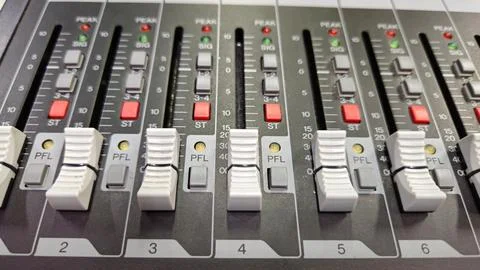 Close-up sliders, buttons and knobs of audio mixer in broadcast studio. Stockfoto's