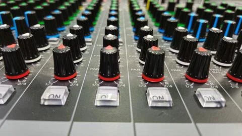 Close-up sliders, buttons and knobs of audio mixer in broadcast studio. Stock Photos