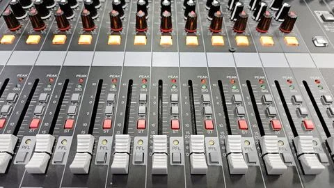 Close-up sliders, buttons and knobs of audio mixer in broadcast studio. Stock Photos